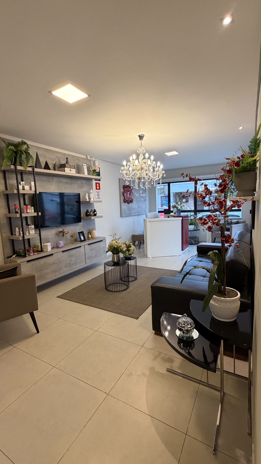 Recepção da clínica Thaís Mendes Estética com lustre de cristal e ambiente acolhedor