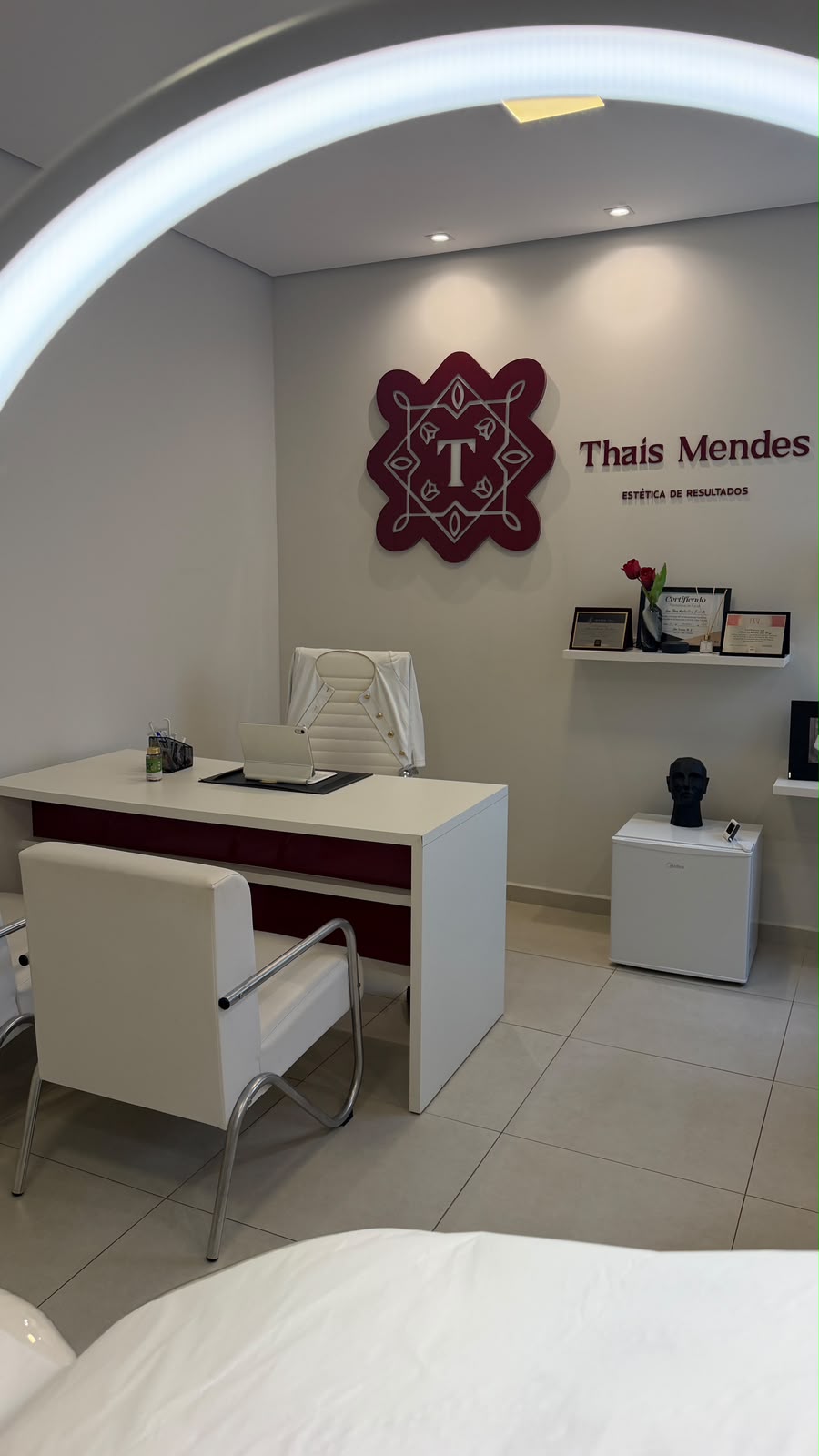 Sala de atendimento da Dra. Thaís Mendes com a marca da clínica na parede